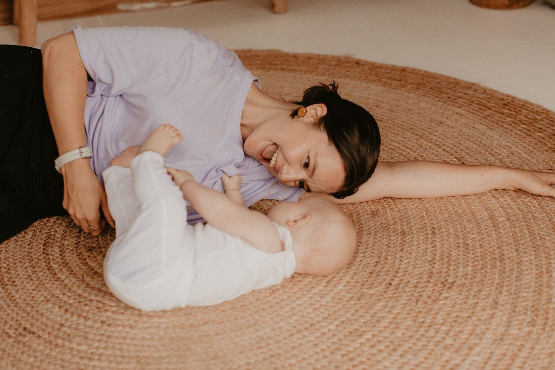 A woman and baby lie on the floor